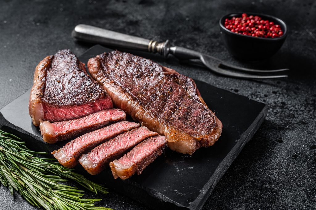 BC Beef, Grilled top sirloin or cup rump beef meat steak on marble board. Black background. Top view